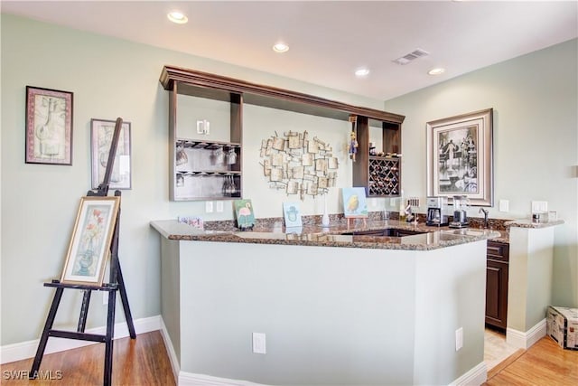 bar with light wood finished floors, indoor wet bar, visible vents, and recessed lighting