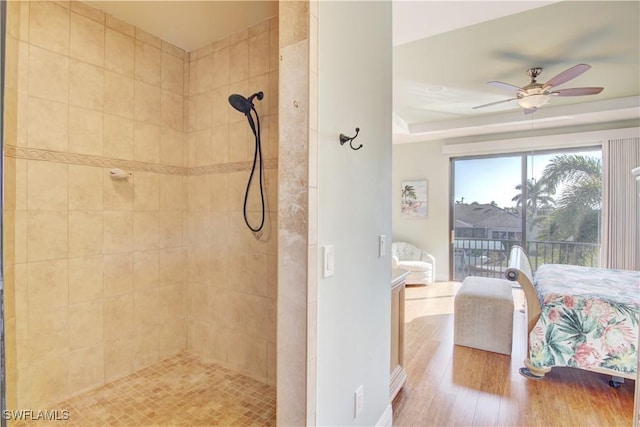 ensuite bathroom featuring a ceiling fan, a tile shower, ensuite bathroom, and wood finished floors