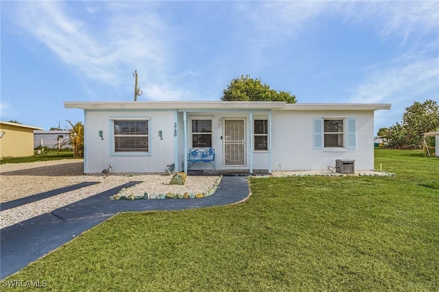 view of front of property with a front yard and central AC