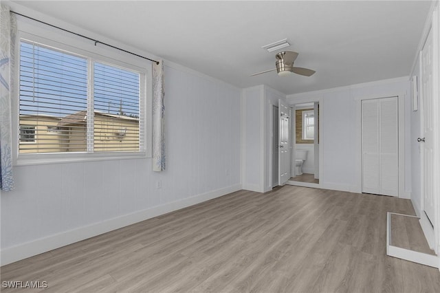 unfurnished bedroom featuring visible vents, baseboards, a ceiling fan, connected bathroom, and wood finished floors