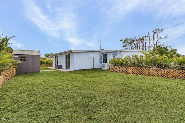 back of property featuring a shed, a lawn, and an outdoor structure