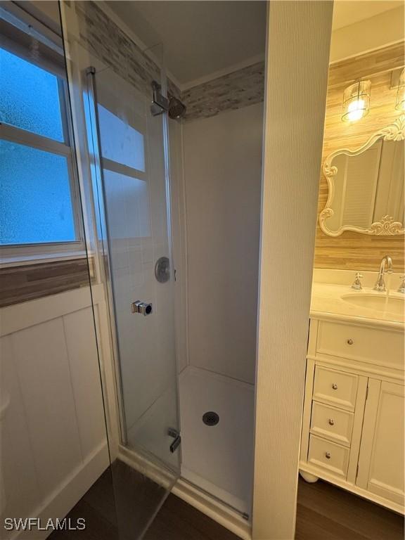 full bath featuring a shower stall, vanity, and wood finished floors