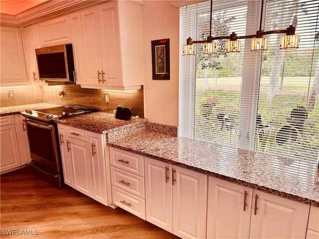 kitchen featuring backsplash, appliances with stainless steel finishes, light wood-style floors, white cabinetry, and light stone countertops