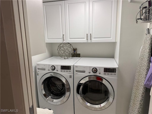 washroom with cabinet space and washer and dryer