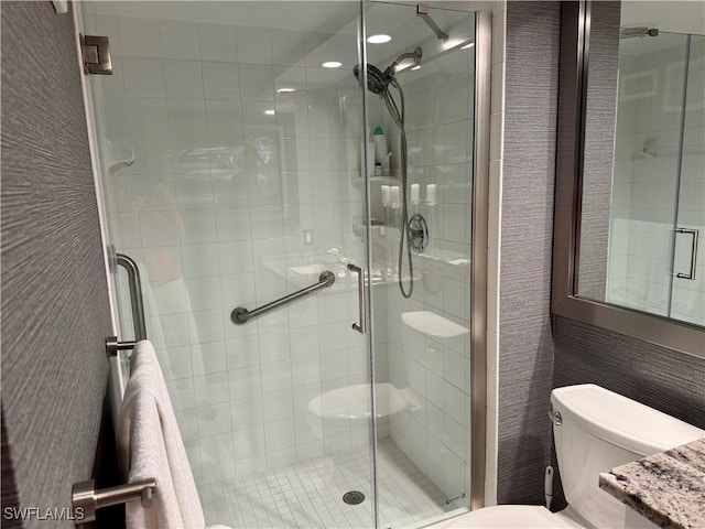 bathroom featuring a stall shower, vanity, and toilet