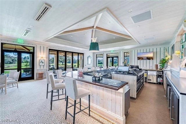 kitchen featuring a spacious island, visible vents, a tray ceiling, and french doors