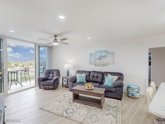 living room featuring hardwood / wood-style floors, floor to ceiling windows, and ceiling fan