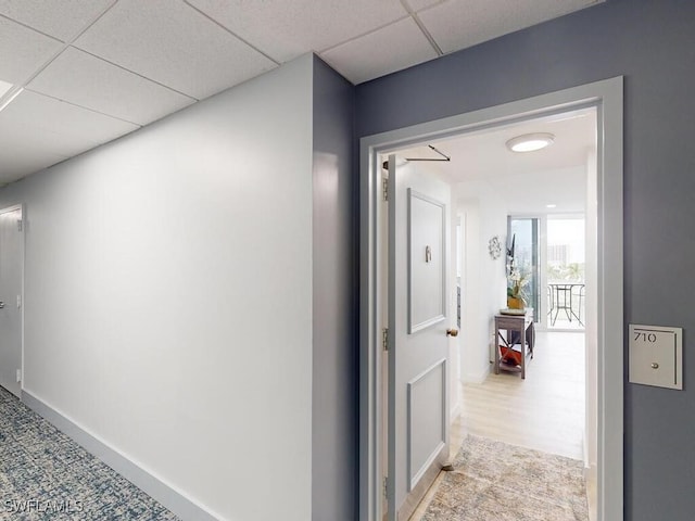 hallway with a paneled ceiling