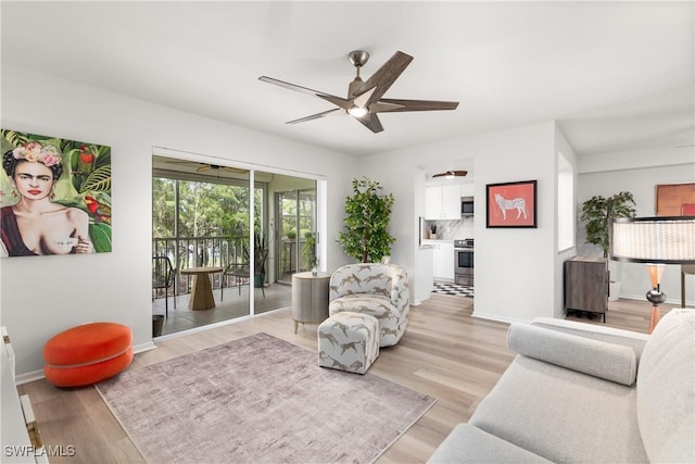 living room featuring light hardwood / wood-style floors and ceiling fan