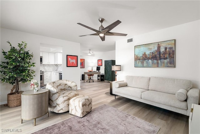 living room featuring ceiling fan and light wood-type flooring