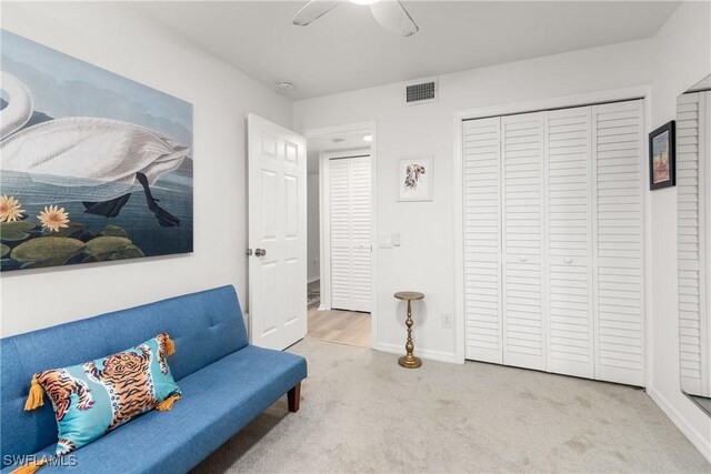 sitting room featuring ceiling fan and light colored carpet