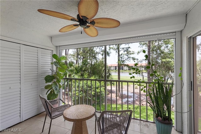 sunroom / solarium featuring ceiling fan, a water view, and plenty of natural light