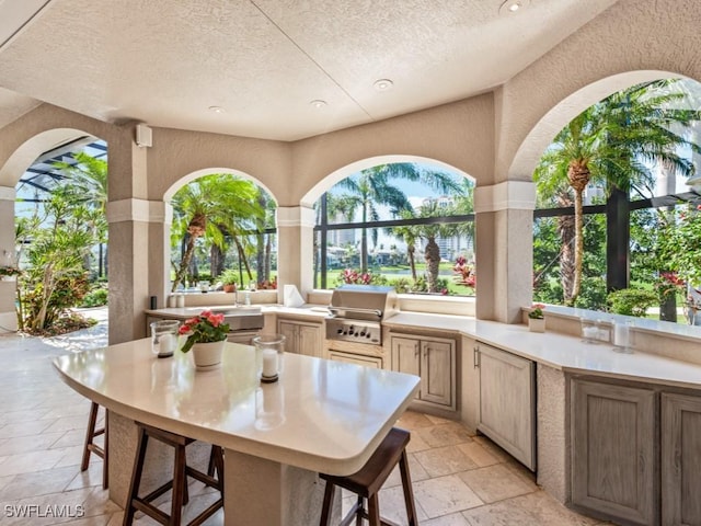 view of patio / terrace featuring a grill, exterior bar, and exterior kitchen