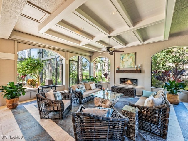 view of patio / terrace featuring ceiling fan and an outdoor living space with a fireplace