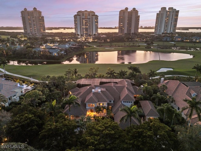 aerial view at dusk featuring a water view