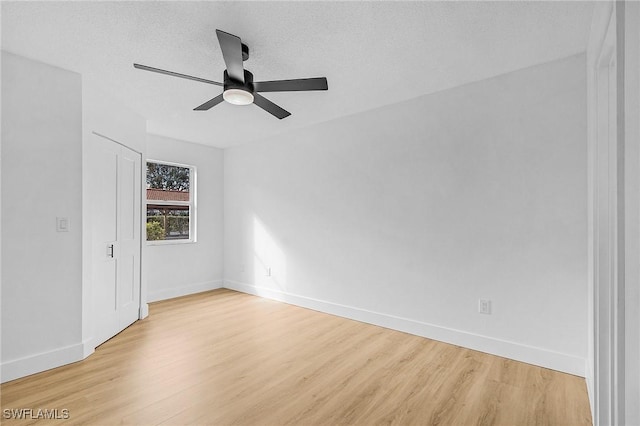 unfurnished bedroom with a textured ceiling, ceiling fan, light wood-type flooring, and baseboards