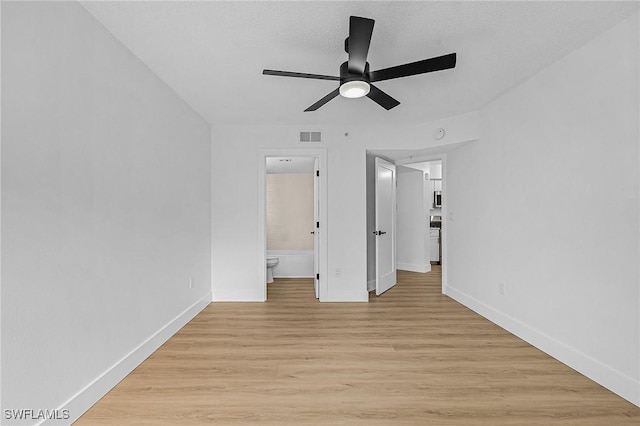 unfurnished bedroom featuring baseboards, connected bathroom, visible vents, and light wood-style floors