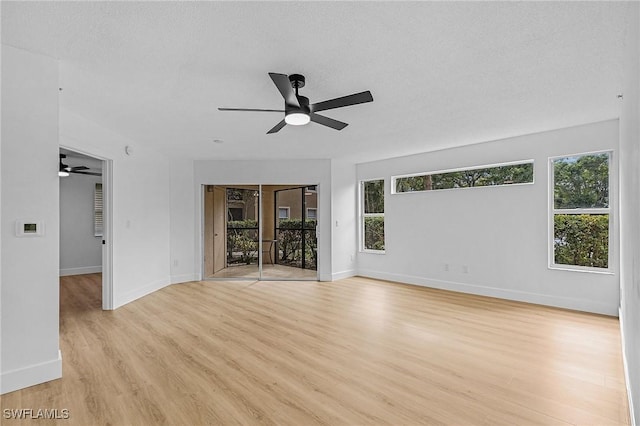 empty room with a ceiling fan, baseboards, and light wood-type flooring