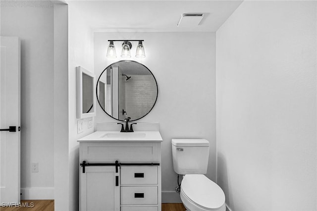 bathroom with wood finished floors, toilet, baseboards, and vanity