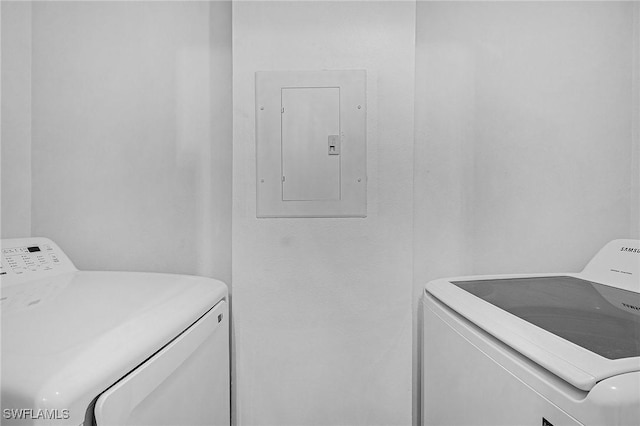 clothes washing area featuring electric panel, washing machine and clothes dryer, and laundry area