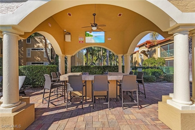 view of patio / terrace with fence, outdoor dry bar, a ceiling fan, and visible vents