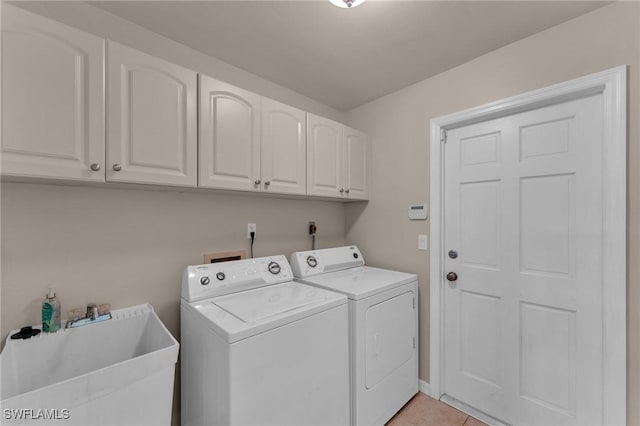 laundry room featuring washing machine and dryer, cabinets, light tile patterned floors, and sink