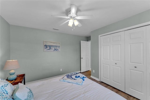 bedroom featuring ceiling fan, dark hardwood / wood-style flooring, and a closet