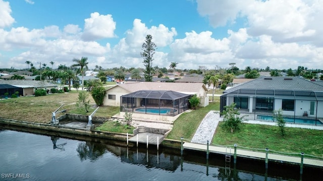 back of house featuring a water view, a lawn, and glass enclosure