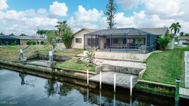 back of house with a water view, a lawn, a patio, and glass enclosure