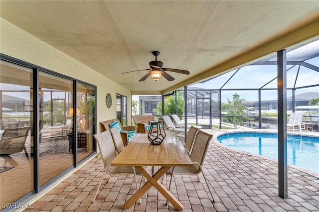 exterior space featuring ceiling fan, glass enclosure, and a patio