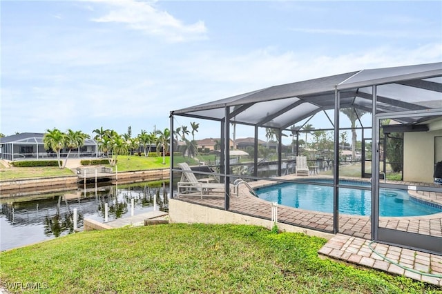 view of pool with glass enclosure, a yard, and a water view