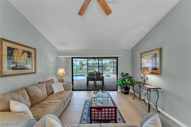 living room featuring ceiling fan, light tile patterned floors, and lofted ceiling