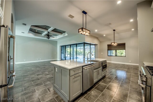 kitchen with decorative light fixtures, stainless steel appliances, a kitchen island with sink, ceiling fan, and coffered ceiling