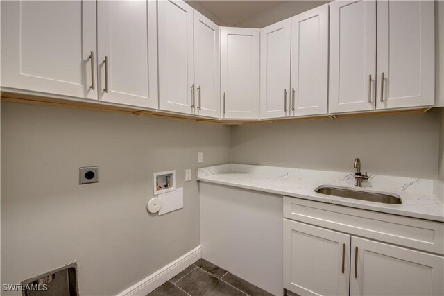 laundry room with dark tile patterned flooring, sink, washer hookup, electric dryer hookup, and cabinets