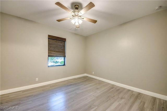 spare room featuring a ceiling fan, wood finished floors, and baseboards