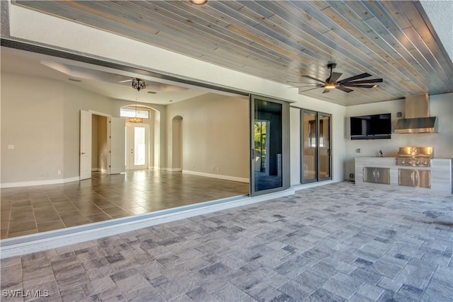 exterior space with baseboards, arched walkways, wood ceiling, and ceiling fan