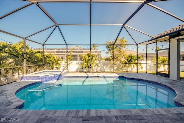 view of pool with glass enclosure, a patio area, and a pool with connected hot tub