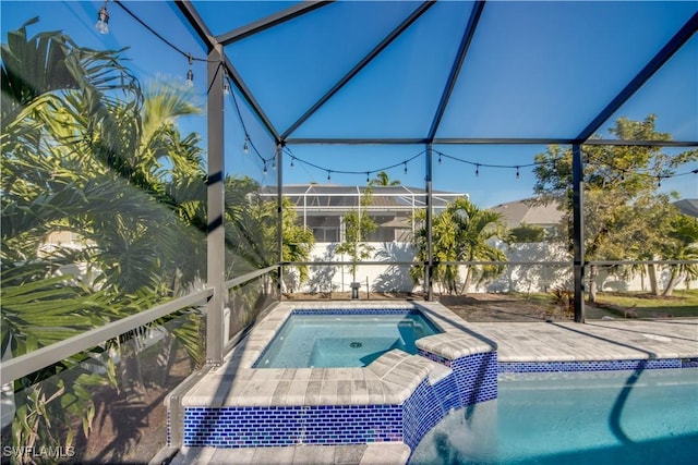 view of swimming pool with an in ground hot tub and a lanai