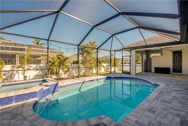 view of swimming pool featuring glass enclosure, an in ground hot tub, and a patio