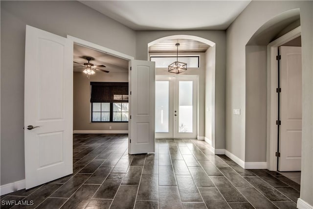 entryway with french doors and ceiling fan with notable chandelier