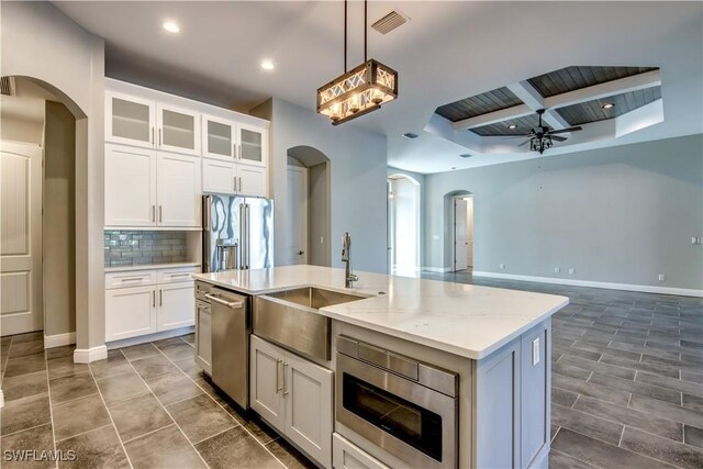 kitchen featuring white cabinets, a kitchen island with sink, appliances with stainless steel finishes, and sink