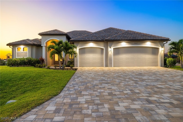 view of front of home with a garage and a yard