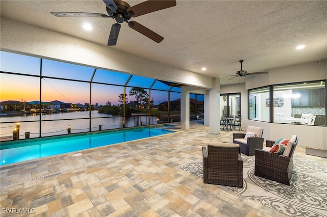 pool at dusk featuring a water view