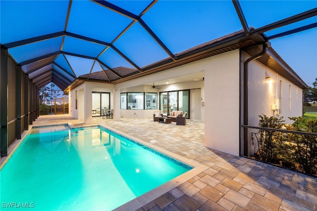 view of pool with a lanai, an outdoor hangout area, ceiling fan, and a patio area