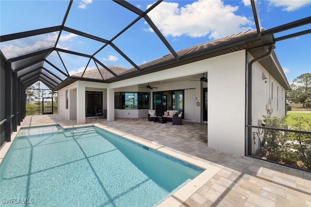 view of pool featuring an outdoor hangout area, a patio area, ceiling fan, and glass enclosure