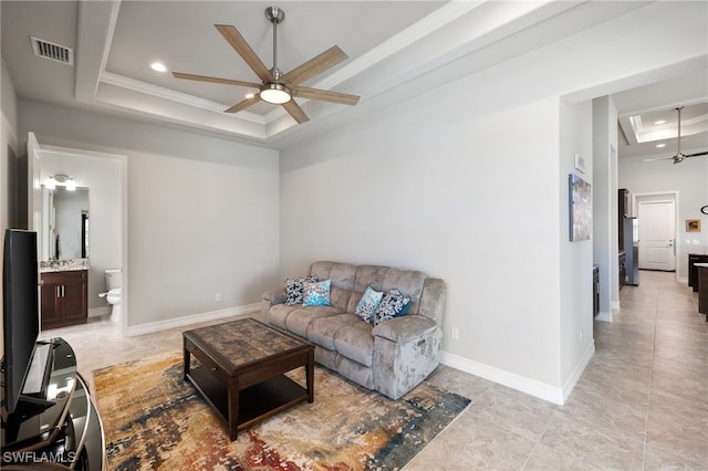 living room with crown molding, ceiling fan, and a tray ceiling