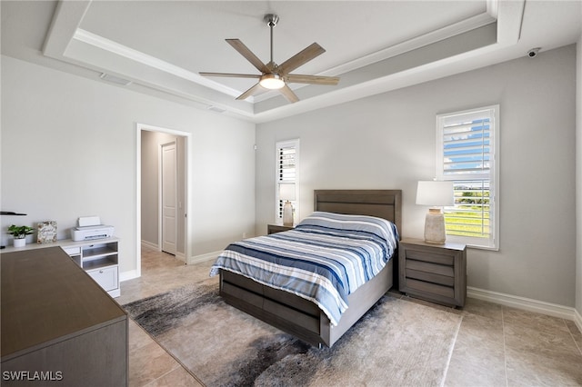 bedroom featuring crown molding, a tray ceiling, ceiling fan, and light tile patterned flooring