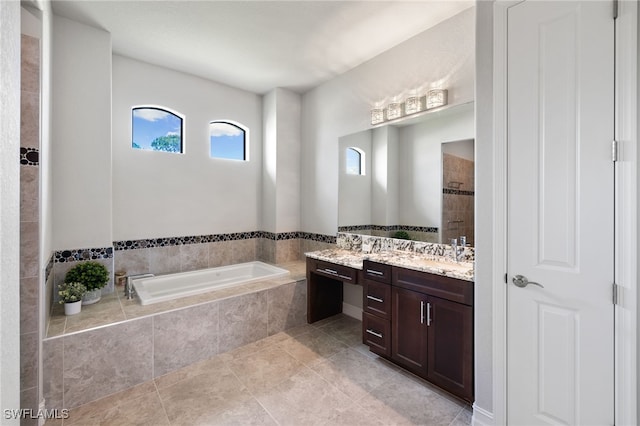 bathroom with vanity, tiled tub, and tile patterned flooring