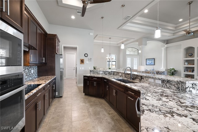 kitchen featuring appliances with stainless steel finishes, pendant lighting, sink, ceiling fan, and a raised ceiling