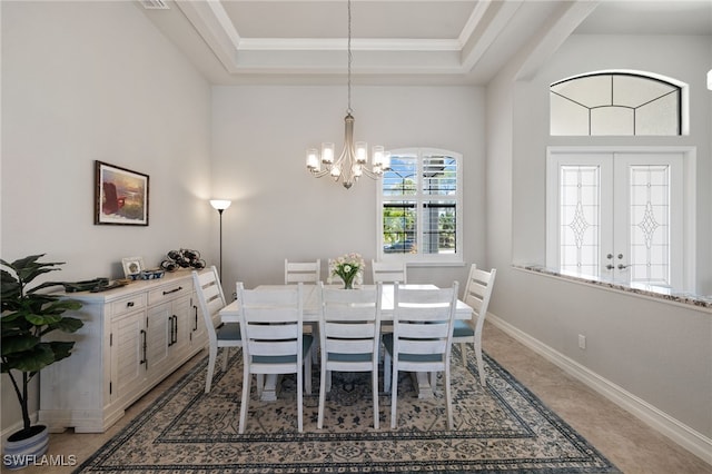 dining space featuring a raised ceiling, crown molding, and an inviting chandelier